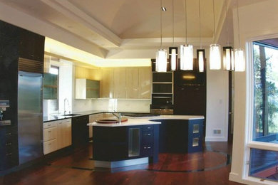 This is an example of a medium sized traditional l-shaped open plan kitchen in Denver with a submerged sink, flat-panel cabinets, black cabinets, engineered stone countertops, white splashback, stone slab splashback, stainless steel appliances, dark hardwood flooring and an island.
