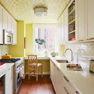 Esempio di una cucina a L tradizionale chiusa e di medie dimensioni con lavello sottopiano, ante in stile shaker, ante bianche, paraspruzzi grigio, paraspruzzi con piastrelle a mosaico, elettrodomestici in acciaio inossidabile, nessuna isola, pavimento marrone e parquet scuro