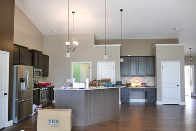 Example of a mid-sized l-shaped eat-in kitchen design in Atlanta with stainless steel appliances and an island