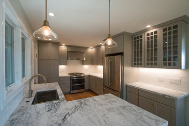Example of a mid-sized trendy galley medium tone wood floor and brown floor eat-in kitchen design in San Francisco with a single-bowl sink, shaker cabinets, gray cabinets, marble countertops, subway tile backsplash, stainless steel appliances and a peninsula