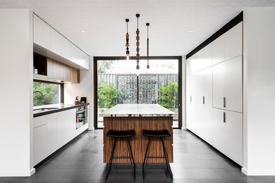 Mittelgroße Moderne Küche mit Unterbauwaschbecken, flächenbündigen Schrankfronten, weißen Schränken, Glasrückwand, Küchengeräten aus Edelstahl und Kücheninsel in Perth