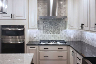Kitchen - mid-sized transitional l-shaped kitchen idea in Other with a farmhouse sink, raised-panel cabinets, white cabinets, white backsplash, marble backsplash, stainless steel appliances and an island