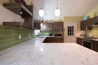 Inspiration for a large modern u-shaped medium tone wood floor and yellow floor eat-in kitchen remodel in Raleigh with a single-bowl sink, flat-panel cabinets, brown cabinets, quartz countertops, green backsplash, glass tile backsplash, stainless steel appliances, a peninsula and multicolored countertops