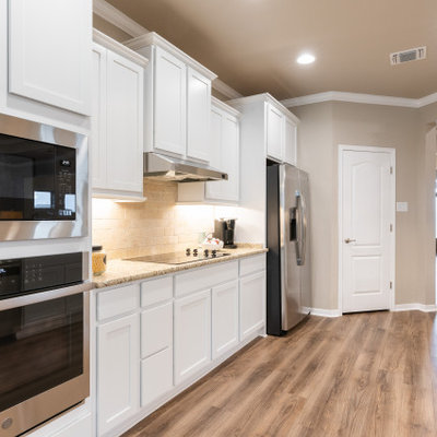 Inspiration for a large craftsman galley open concept kitchen remodel in Austin with an undermount sink, recessed-panel cabinets, white cabinets, granite countertops, beige backsplash, stone tile backsplash, stainless steel appliances, a peninsula and beige countertops