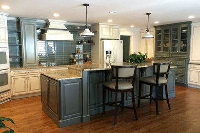 Large transitional u-shaped medium tone wood floor eat-in kitchen photo in Atlanta with raised-panel cabinets, gray cabinets, granite countertops, white appliances, an island and a farmhouse sink