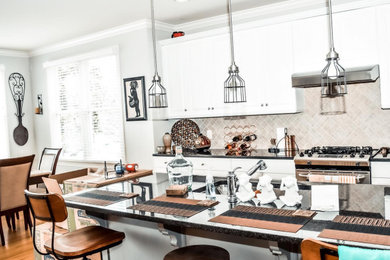 Eat-in kitchen - mid-sized modern single-wall light wood floor and brown floor eat-in kitchen idea in Other with a drop-in sink, flat-panel cabinets, white cabinets, marble countertops, brown backsplash, cement tile backsplash, stainless steel appliances, an island and black countertops