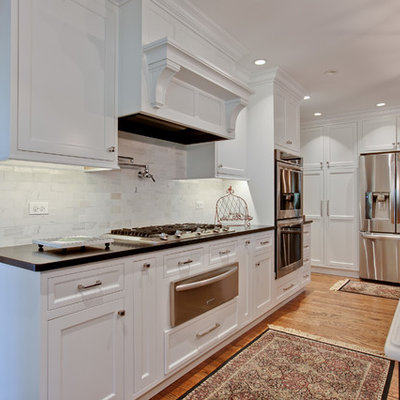Large elegant u-shaped medium tone wood floor eat-in kitchen photo in Chicago with a double-bowl sink, beaded inset cabinets, white cabinets, quartzite countertops, gray backsplash, stone tile backsplash, stainless steel appliances and an island