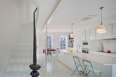 ニューヨークにある高級な中くらいなコンテンポラリースタイルのおしゃれなキッチン (白いキッチンパネル、塗装フローリング) の写真