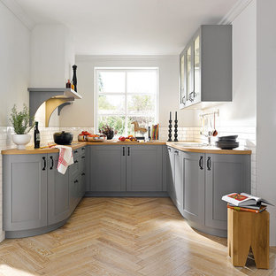 Foto di una cucina ad U classica di medie dimensioni con ante in stile shaker, ante grigie, top in legno, paraspruzzi bianco, paraspruzzi con piastrelle diamantate, parquet chiaro e nessuna isola