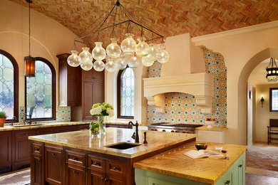 Inspiration for a mediterranean u-shaped enclosed kitchen remodel in Austin with beaded inset cabinets, dark wood cabinets and multicolored backsplash