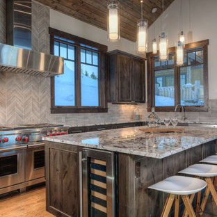 Ispirazione per una cucina a L stile rurale con ante con riquadro incassato, ante in legno bruno, paraspruzzi grigio, elettrodomestici in acciaio inossidabile, pavimento in legno massello medio, isola e top multicolore