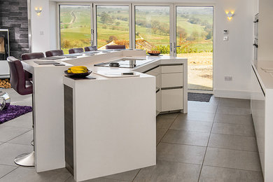 Large contemporary u-shaped open plan kitchen in Other with a built-in sink, flat-panel cabinets, white cabinets, composite countertops, brown splashback, stainless steel appliances, porcelain flooring and an island.