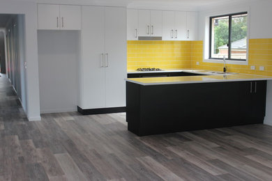 Idee per una cucina abitabile moderna con paraspruzzi giallo e pavimento in vinile