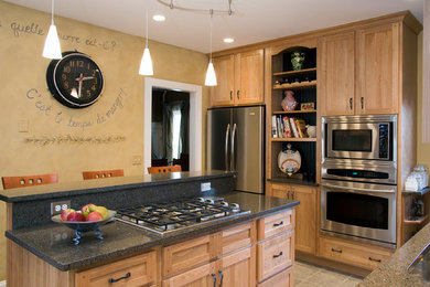 Example of a mid-sized arts and crafts ceramic tile kitchen pantry design in Boston with an undermount sink, light wood cabinets, quartz countertops, stainless steel appliances and an island