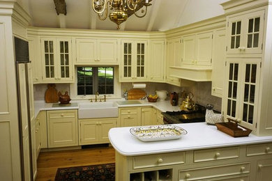 Medium tone wood floor kitchen photo in Other with yellow cabinets