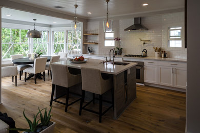 Enclosed kitchen - large transitional single-wall light wood floor and brown floor enclosed kitchen idea in Los Angeles with an undermount sink, shaker cabinets, white cabinets, marble countertops, white backsplash, subway tile backsplash, stainless steel appliances and an island