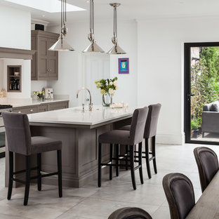 Inspiration for a medium sized classic single-wall kitchen/diner in Surrey with a submerged sink, shaker cabinets, grey cabinets, stainless steel appliances, an island, grey floors and white worktops.