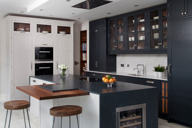 Moderne Küche in L-Form mit Schrankfronten im Shaker-Stil, Quarzit-Arbeitsplatte, Kücheninsel, Unterbauwaschbecken, schwarzen Schränken, Küchenrückwand in Weiß und weißem Boden in Sonstige