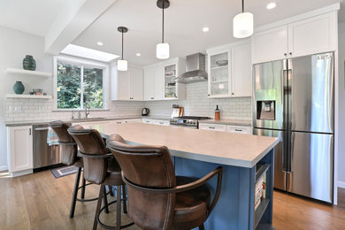 Mid-sized transitional l-shaped medium tone wood floor and brown floor open concept kitchen photo in San Francisco with an undermount sink, shaker cabinets, white cabinets, quartz countertops, white backsplash, subway tile backsplash, stainless steel appliances, an island and gray countertops