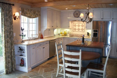 Inspiration for a mid-sized timeless l-shaped eat-in kitchen remodel in San Diego with a double-bowl sink, raised-panel cabinets, white cabinets, stainless steel appliances, an island, granite countertops, beige backsplash and ceramic backsplash