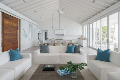 Large beach style u-shaped concrete floor and gray floor eat-in kitchen photo in Miami with an undermount sink, flat-panel cabinets, white cabinets, marble countertops, white backsplash, stone slab backsplash, white appliances, an island and white countertops