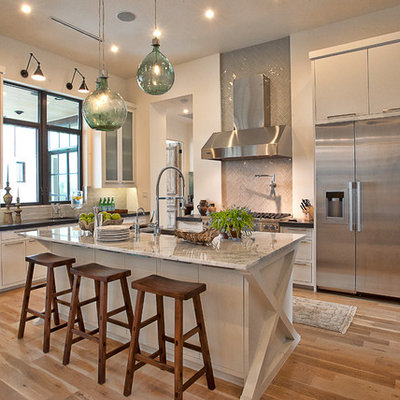 Inspiration for a transitional kitchen remodel in Austin with flat-panel cabinets, stainless steel appliances, marble countertops, white cabinets, gray backsplash and glass tile backsplash