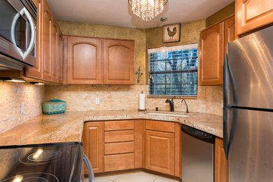 Example of a small transitional u-shaped ceramic tile enclosed kitchen design in Phoenix with an undermount sink, raised-panel cabinets, granite countertops, multicolored backsplash, stone tile backsplash, black appliances and no island
