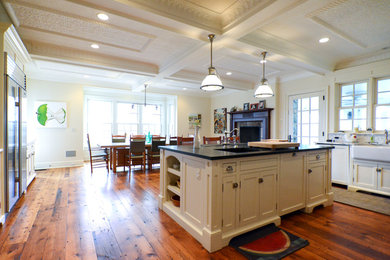 Large elegant u-shaped medium tone wood floor and brown floor eat-in kitchen photo in New York with a farmhouse sink, shaker cabinets, white cabinets, marble countertops, white backsplash, stone slab backsplash, stainless steel appliances and an island