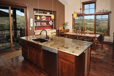 Large transitional single-wall medium tone wood floor eat-in kitchen photo in Denver with an undermount sink, raised-panel cabinets, medium tone wood cabinets, granite countertops, stainless steel appliances and an island