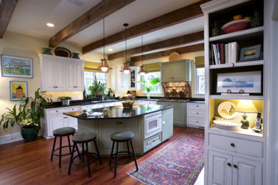 Inspiration for a mid-sized timeless u-shaped medium tone wood floor eat-in kitchen remodel in Charleston with beaded inset cabinets, white cabinets, concrete countertops, beige backsplash, white appliances and an island