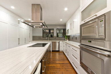 Transitional u-shaped eat-in kitchen photo in Austin with an undermount sink, recessed-panel cabinets, white cabinets, granite countertops, gray backsplash, porcelain backsplash and stainless steel appliances