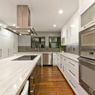 Transitional eat-in kitchen designs - Transitional u-shaped eat-in kitchen photo in Austin with an undermount sink, recessed-panel cabinets, white cabinets, granite countertops, gray backsplash, porcelain backsplash and stainless steel appliances