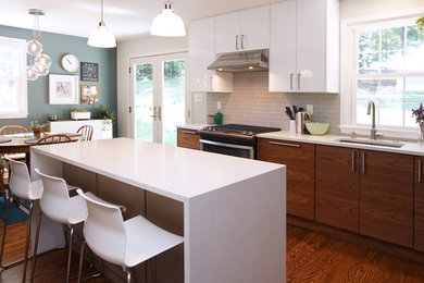 Inspiration for a mid-sized contemporary l-shaped medium tone wood floor and brown floor eat-in kitchen remodel in Philadelphia with an undermount sink, quartz countertops, gray backsplash, stainless steel appliances, an island, flat-panel cabinets, white cabinets and ceramic backsplash