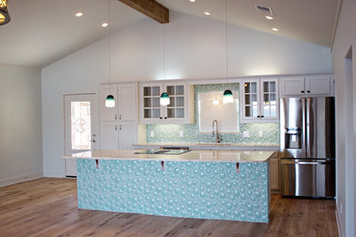 ダラスにあるラグジュアリーな小さなビーチスタイルのおしゃれなキッチン (シングルシンク、ガラス扉のキャビネット、白いキャビネット、大理石カウンター、青いキッチンパネル、シルバーの調理設備、淡色無垢フローリング) の写真