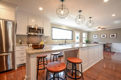 Large transitional galley medium tone wood floor and brown floor eat-in kitchen photo in Little Rock with a double-bowl sink, shaker cabinets, white cabinets, granite countertops, green backsplash, stainless steel appliances and an island