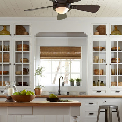 Inspiration for a small rustic galley medium tone wood floor enclosed kitchen remodel in New York with an undermount sink, open cabinets, white cabinets, wood countertops, white backsplash, cement tile backsplash, stainless steel appliances and an island