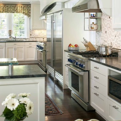Kitchen - traditional l-shaped kitchen idea in Boston with soapstone countertops, stainless steel appliances, white cabinets and gray backsplash