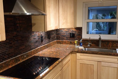 Example of a trendy kitchen design in Tampa with an undermount sink, shaker cabinets, light wood cabinets, quartz countertops, brown backsplash and glass tile backsplash