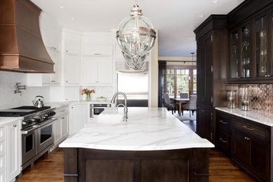 Elegant u-shaped medium tone wood floor eat-in kitchen photo in Portland with a farmhouse sink, recessed-panel cabinets, dark wood cabinets, marble countertops, mosaic tile backsplash, stainless steel appliances and an island