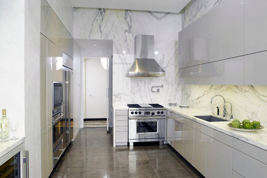 ニューヨークにある高級な広いコンテンポラリースタイルのおしゃれなキッチン (シングルシンク、フラットパネル扉のキャビネット、白いキャビネット、大理石カウンター、白いキッチンパネル、石スラブのキッチンパネル、シルバーの調理設備、コンクリートの床、アイランドなし) の写真