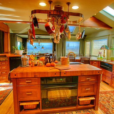 Example of a huge eclectic u-shaped light wood floor eat-in kitchen design in Seattle with a farmhouse sink, recessed-panel cabinets, medium tone wood cabinets, granite countertops, multicolored backsplash, stone slab backsplash, stainless steel appliances and an island