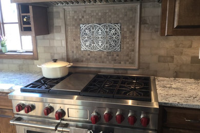 Design ideas for a mediterranean kitchen in Bridgeport with raised-panel cabinets, medium wood cabinets, granite worktops, beige splashback and metro tiled splashback.