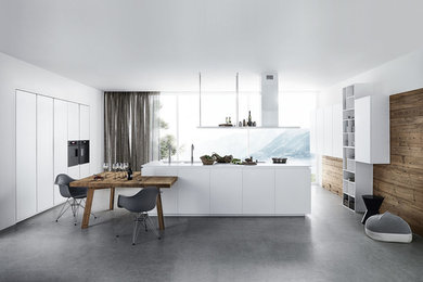 Foto på ett stort funkis kök, med grå skåp, träbänkskiva, svarta vitvaror och en köksö