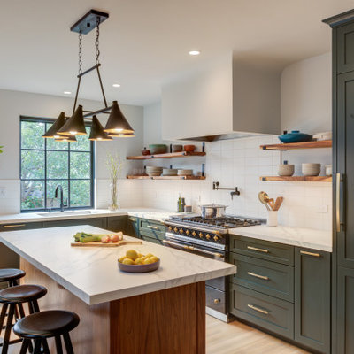 Eat-in kitchen - large transitional l-shaped light wood floor and brown floor eat-in kitchen idea in San Francisco with an undermount sink, shaker cabinets, green cabinets, quartz countertops, white backsplash, ceramic backsplash, black appliances, an island and white countertops