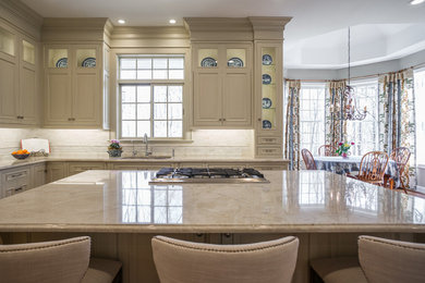 Kitchen - traditional kitchen idea in Philadelphia with a drop-in sink, quartzite countertops, paneled appliances and an island