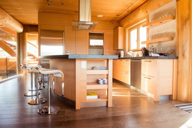 Exemple d'une grande cuisine ouverte linéaire chic en bois clair avec un évier encastré, un placard à porte plane, un plan de travail en granite, une crédence blanche, un électroménager en acier inoxydable, un sol en bois brun et îlot.