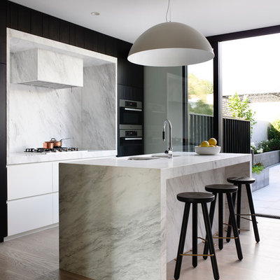 Danish galley light wood floor kitchen photo in Melbourne with a double-bowl sink, flat-panel cabinets, white backsplash, stainless steel appliances and an island