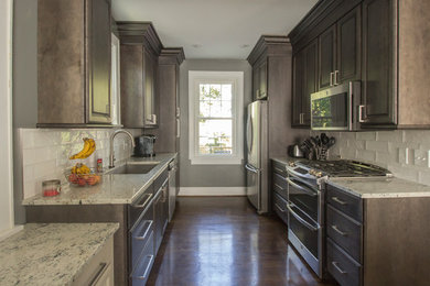 Inspiration for a small galley kitchen/diner in Cincinnati with a built-in sink, dark wood cabinets, granite worktops, white splashback, stainless steel appliances, dark hardwood flooring and no island.