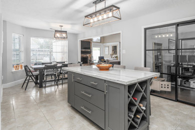 Inspiration for a large modern eat-in kitchen remodel with an undermount sink, flat-panel cabinets, gray cabinets, quartzite countertops, white backsplash, ceramic backsplash, stainless steel appliances, an island and white countertops