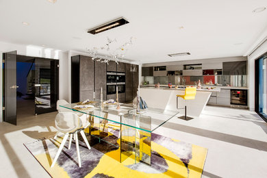 ハートフォードシャーにある巨大なコンテンポラリースタイルのおしゃれなキッチン (ガラス板のキッチンパネル、黒い調理設備、大理石の床) の写真